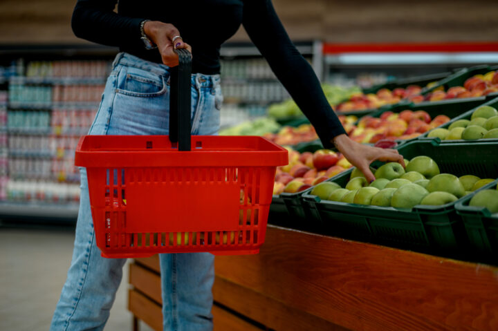 Woman in a supermarket holding shopping cart while grocery shopp